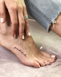 Tatuagem feminina no pé com frases