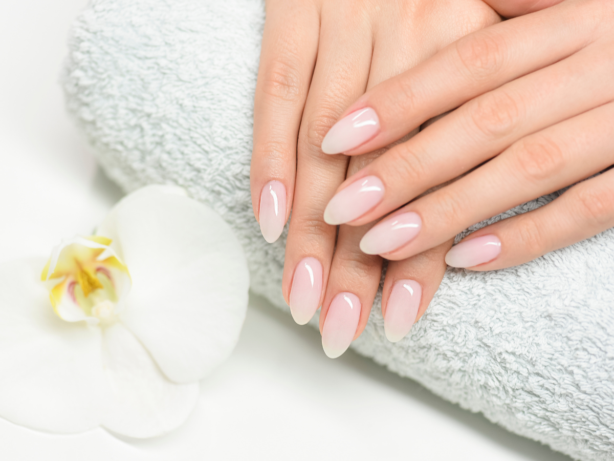 Unhas almond. Foto mãos sobre toalha 