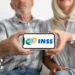 Prova de vida 2025: É possível regularizar seu INSS sem sair de casa? 11 Casal de idosos exibindo um smartphone com o logo do INSS, representando a digitalização da prova de vida.