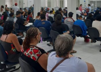 Pessoas sentadas em cadeiras em uma sala de espera do INSS, simbolizando a grande procura pelas 4.500 vagas oferecidas no mutirão de outubro de 2025.