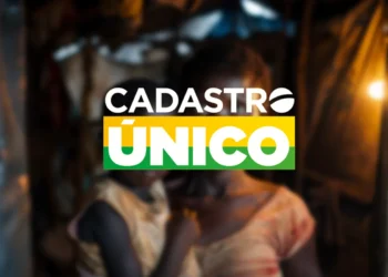 Logotipo do Cadastro Único (CadÚnico) com a palavra “ÚNICO” em verde e amarelo, sobre fundo desfocado que representa famílias de baixa renda.