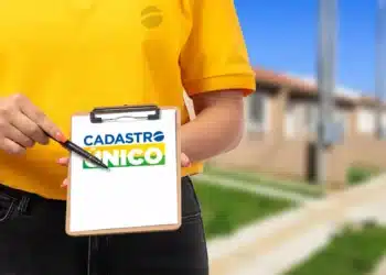 Mulher em camisa amarela segurando prancheta com logo "Cadastro Único", simbolizando a modernização e o atendimento para programas sociais do Governo Federal.