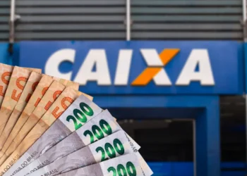 Notas de Real (R$ 50 e R$ 200) em frente a uma agência da Caixa Econômica Federal, simbolizando o saque de valores prorrogados.