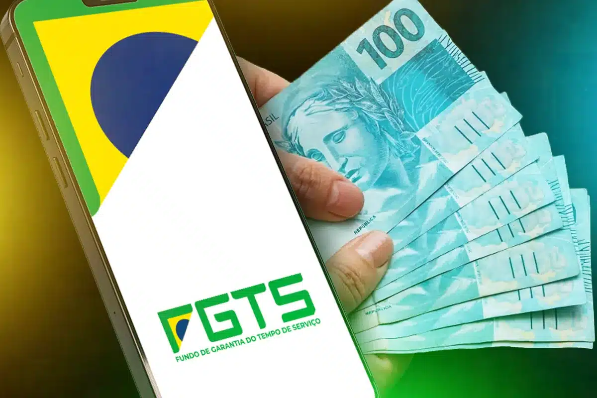 FGTS-Saque-Aniversario-Adesao-App-Caixa-Dinheiro-Trabalhadores Mão segurando um smartphone com o logo do FGTS e a bandeira do Brasil na tela, ao lado de notas de R$ 100. Imagem ilustra a facilidade de adesão e a possibilidade de saque para todos os trabalhadores com saldo no Fundo de Garantia.