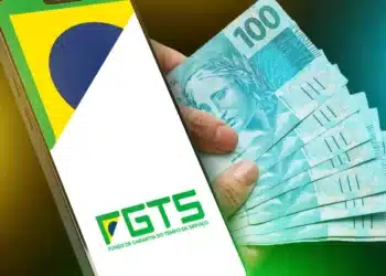 Aplicativo FGTS no celular e notas de R$ 100 representando o novo limite de R$ 500 na antecipação do Saque-Aniversário.