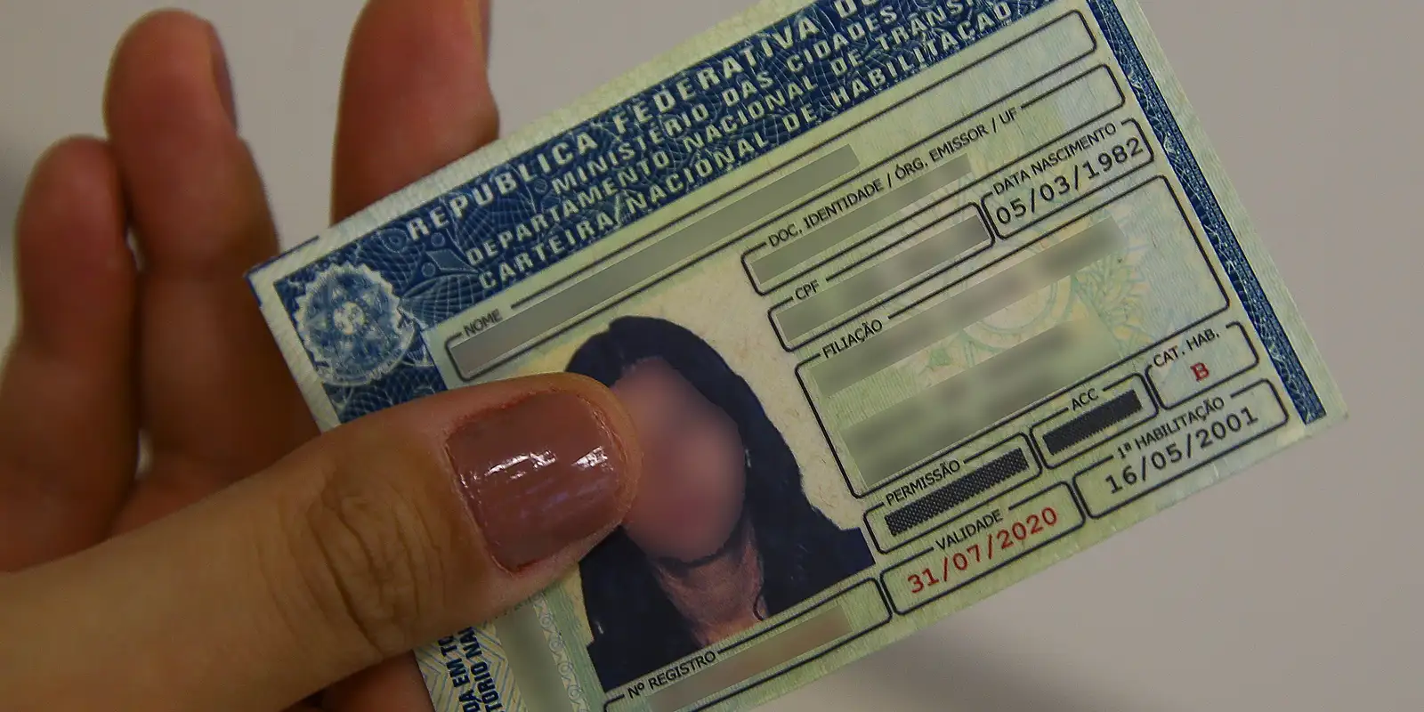 CNH e as Próximas Mudanças na Lei de Habilitação Mão segurando a Carteira Nacional de Habilitação (CNH), ilustrando um artigo sobre as futuras mudanças na lei da CNH para motoristas.