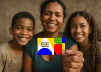 Liberada antecipação do Bolsa Família! Veja a lista dos beneficiários que recebem amanhã (14) 2 Mulher sorridente com duas crianças segurando cartão do Programa Bolsa Família colorido