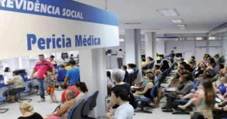 Interior de uma agência da Previdência Social, com várias pessoas aguardando para realizar a perícia médica durante o mutirão.