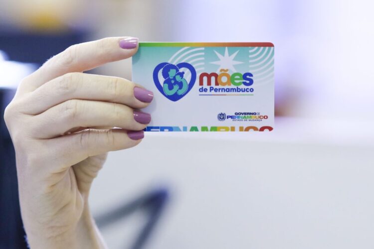 Mulher segura o Cartão Mães de Pernambuco, benefício social de R$ 300 para mães em vulnerabilidade.