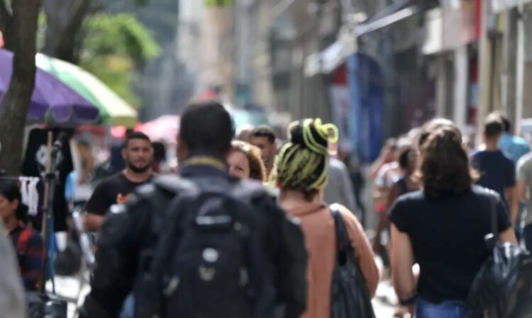Rua movimentada com várias pessoas caminhando, representando a diversidade de nomes comuns no Brasil, conforme pesquisa do IBGE.