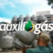 Auxílio Gás cortado: famílias menores e unipessoais perderam benefício de R$ 110,00; entenda motivo 11 Homem de costas carregando um botijão de gás prata em um depósito cheio, com o logotipo branco "auxílio gás" sobreposto à imagem.