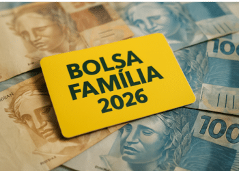 Cartão amarelo escrito Bolsa Família 2026 sobre notas de dinheiro brasileiro