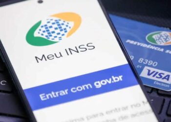 Aplicativo Meu INSS exibido em smartphone ao lado de cartão de previdência social, representando serviços e atendimentos do INSS.