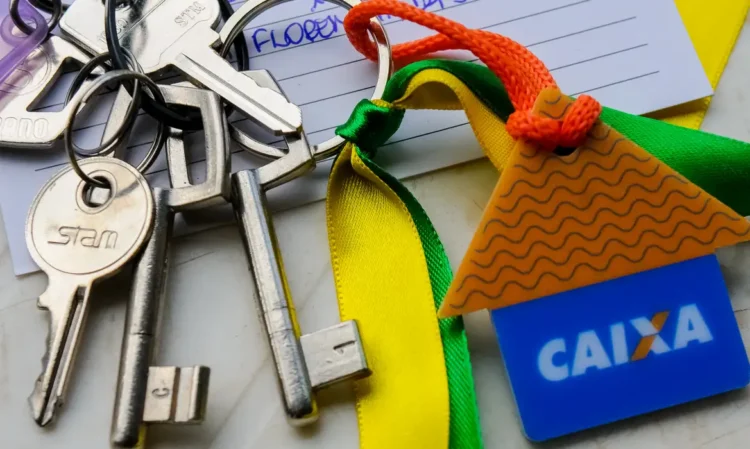 Conjunto de chaves metálicas em argola com pingente colorido em formato de casa da Caixa Econômica Federal