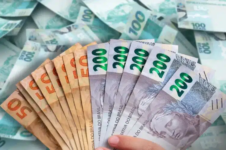 Cédulas de real organizadas em leque, representando repasse de dinheiro pelo Caixa Tem.