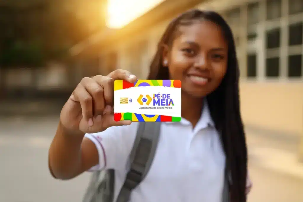 artão Pé de Meia para estudantes do ensino médio. Jovem segurando cartão colorido Pé de Meia, poupança para ensino médio.