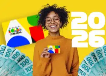 Mulher sorrindo e segurando o cartão do Bolsa Família de 2026 com notas de R$100 reais ao fundo.