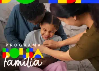 Família interagindo alegremente em casa, com a criança sorrindo enquanto os pais brincam com ela. Imagem de uma família participando do programa social Bolsa Família.