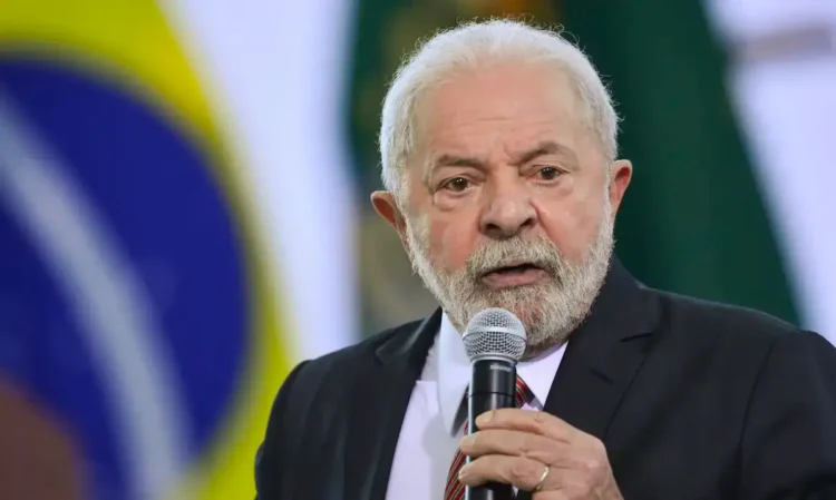 Presidente Lula diz que salário mínimo de R$ 1.621 é baixo e quer novo aumento 1 Lula discursando em evento com bandeira do Brasil ao fundo.