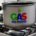 Gás do Povo: 15 milhões de lares poderão recarregar o gás de cozinha de graça até março 11 Panela com logo Gás do Povo aquece no fogão aceso em cozinha residencial.
