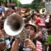 Carnaval 2026: veja os horários de atendimento dos bancos 11 Músicos com fantasias tocam trompete e trombone em meio à multidão festiva em bloco carnavalesco