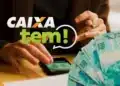 Caixa Tem libera R$ 600 em 18 de março; confira se você está na lista 2 Imagem ilustrativa do aplicativo Caixa Tem em um celular ao lado de notas de dinheiro, representando o pagamento do Bolsa Família realizado pela Caixa Econômica Federal. O benefício mínimo de R$ 600 começa a ser depositado em março seguindo o calendário baseado no número final do NIS.