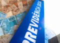 Notas de real sobre placa azul da Previdência Social, simbolizando liberação bilionária do INSS.