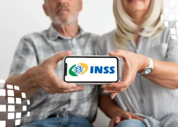 Nova regra do INSS pode garantir benefício sem perícia; veja como 7 Casal sênior segurando smartphone horizontal mostrando logotipo do INSS, homem de barba grisalha e mulher loira.