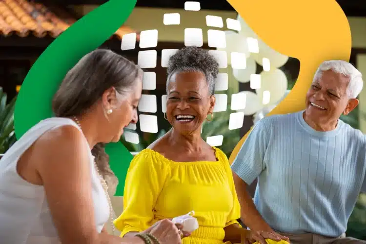 Vai ter pagamento do 13º salário do INSS nesta sexta-feira, 1º de maio? 2 Três idosos sorridentes sentados ao ar livre em área com telhado colonial e vegetação tropical.