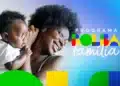 Caixa libera Bolsa Família para 4 grupos nesta semana; veja valores e datas 12 Mulher negra de cabelo afro e óculos segura bebê; logo do Programa Bolsa Família com cores verde, amarelo, vermelho e azul.