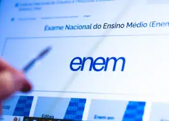 Quer fazer o Enem sem pagar? Prazo para isenção começa hoje (13) 10 Tela do portal do Enem no Inep com logotipo azul em destaque e mão segurando caneta apontando para informações.