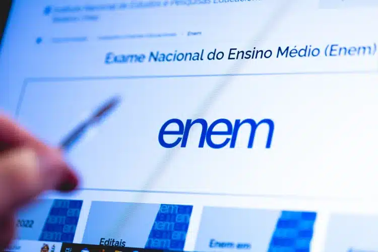 Quer fazer o Enem sem pagar? Prazo para isenção começa hoje (13) 1 Tela do portal do Enem no Inep com logotipo azul em destaque e mão segurando caneta apontando para informações.
