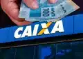 Saque Calamidade é disponibilizado pela CAIXA a moradores de cidades do Pará (PA) 14 Mão segura cédulas de R$ 100 em frente à fachada da Caixa Econômica Federal, banco responsável pelo Saque Calamidade do FGTS