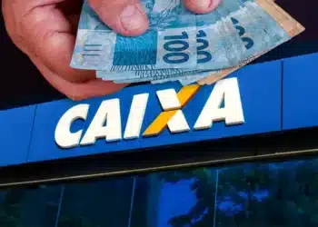 Saque Calamidade é disponibilizado pela CAIXA a moradores de cidades do Pará (PA) 6 Mão segura cédulas de R$ 100 em frente à fachada da Caixa Econômica Federal, banco responsável pelo Saque Calamidade do FGTS