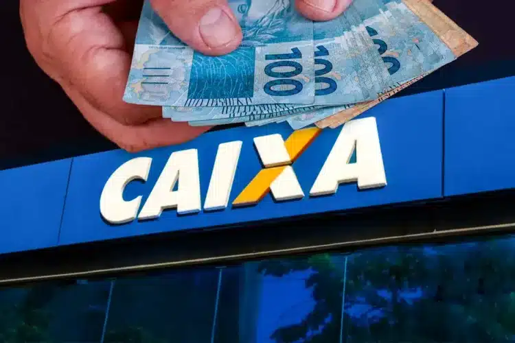 Saque Calamidade é disponibilizado pela CAIXA a moradores de cidades do Pará (PA) 1 Mão segura cédulas de R$ 100 em frente à fachada da Caixa Econômica Federal, banco responsável pelo Saque Calamidade do FGTS