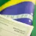 Situação eleitoral: como saber se seu título está apto para votar em 2026 12 Título eleitoral da República Federativa do Brasil com identificação biométrica em primeiro plano e bandeira brasileira ao fundo.