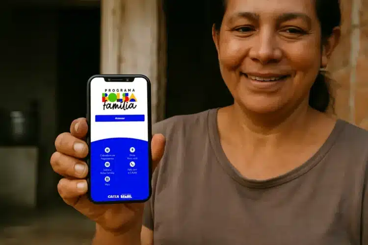 Bolsa Família de maio abre consulta no app; veja quando você recebe 1 Mulher segurando celular com aplicativo do Bolsa Família aberto na tela