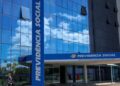 Fachada de vidro azul do edifício-sede da Previdência Social, com o letreiro do INSS na entrada