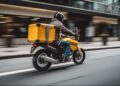Motociclista com baú amarelo de delivery circula em avenida urbana