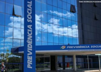 Fachada do edifício-sede do INSS com vidros espelhados azuis e letreiro "Previdência Social" em Brasília