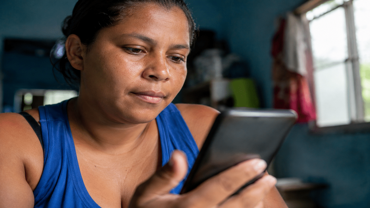Bolsa Família 2026 devolve valores não sacados em até 180 dias, dinheiro parado retorna ao governo federal automaticamente 2 Beneficiária verifica informações da parcela pelo celular em casa