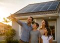 Família observa placas de energia solar instaladas no telhado da casa