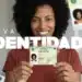 Adeus, RG antigo: mutirão realiza nova rodada para emissão da Carteira de Identidade Nacional nesta semana 12 Mulher sorridente segura nova carteira de identidade brasileira com destaque para o documento e fundo claro